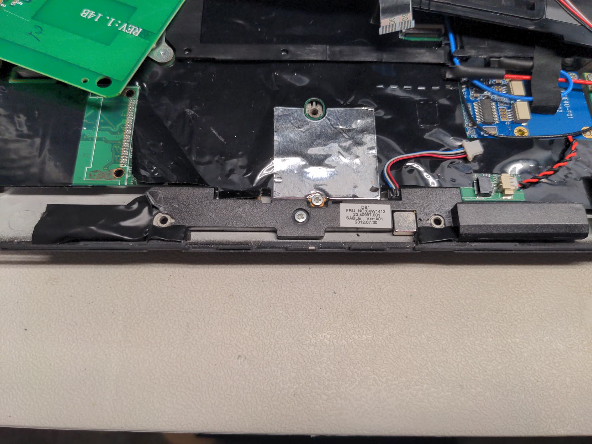 Laptop with speaker assembly missing a piece and taped over