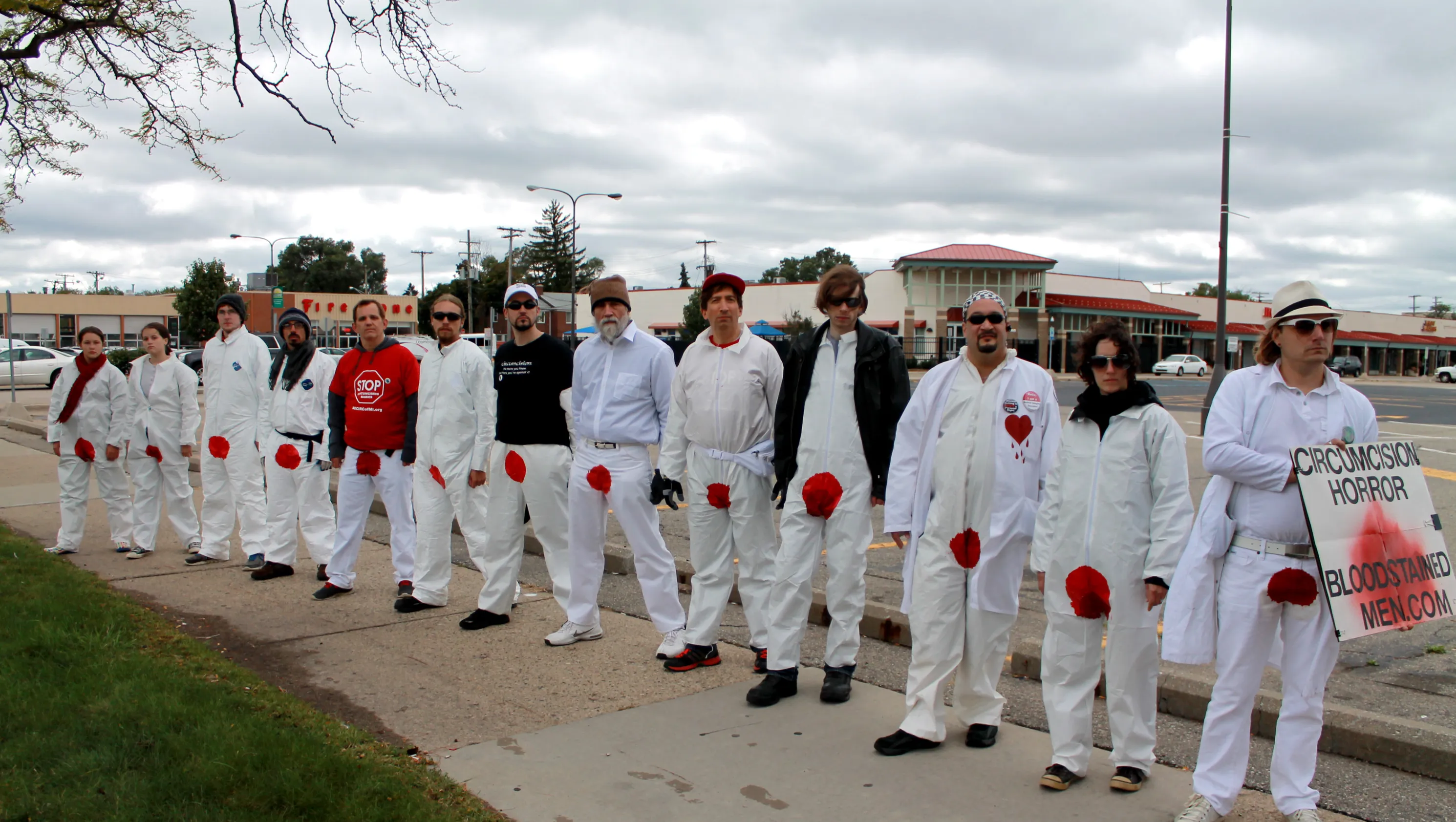 Lineup of 'Bloodstained Men' in white suits with bloody groin